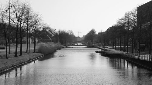 Canal amidst trees against clear sky
