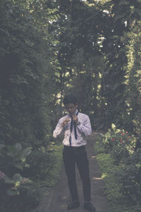 Full length of man standing by tree in forest