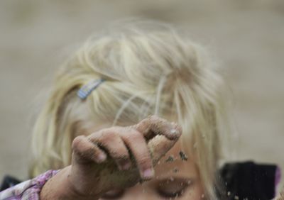 Cropped image of girl playing with sand at playground