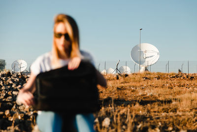 Midsection of woman using mobile phone against clear sky