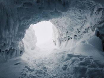 Scenic view of frozen sea seen through cave