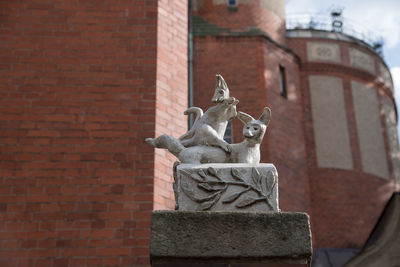 Statue against brick wall