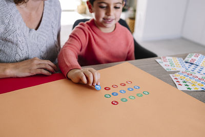 Mother and son making crafts at home with cardstocks and stickers