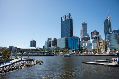 City at waterfront against blue sky