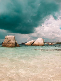 Rocks on sea shore against sky