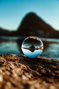 Close-up of crystal ball with reflection in water