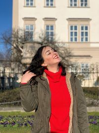 Portrait of young woman standing in city