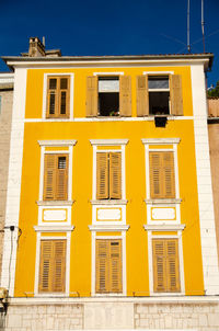 Low angle view of yellow building against sky