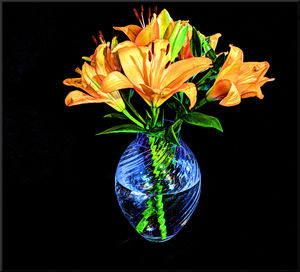 Close-up of illuminated lamp over black background