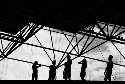 Low angle view of silhouette people against sky