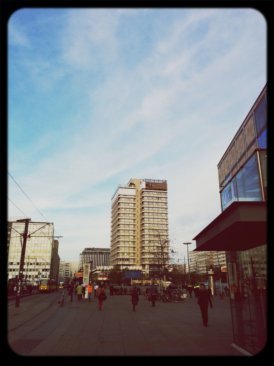 architecture, building exterior, built structure, transfer print, sky, city, auto post production filter, city life, large group of people, cloud - sky, men, street, cloud, person, building, lifestyles, day, leisure activity, outdoors