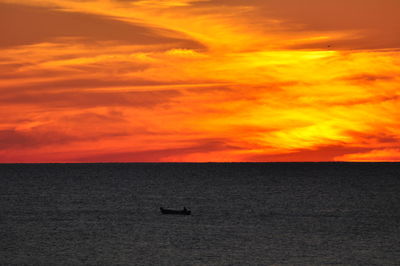 Scenic view of sea against orange sky