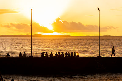 Silhouette of people, at sunset, on the porto da barra pier in the city of salvador, bahia.
