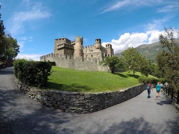 Lawn by castle against sky