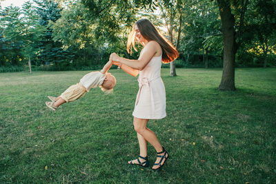 Full length of woman playing with son at park