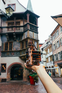Cropped hand of woman holding model house