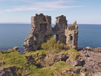 Castle by sea against sky