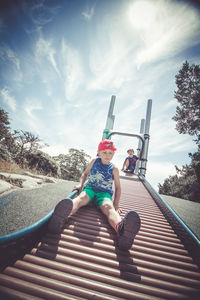 Woman sitting on bicycle against sky