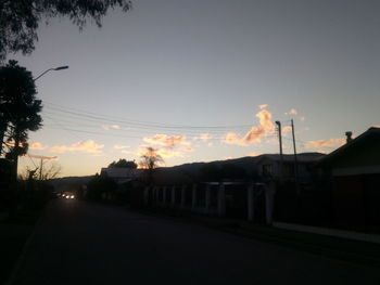 Smoke emitting from factory against sky at sunset