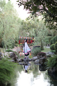 Rear view of woman standing in lake