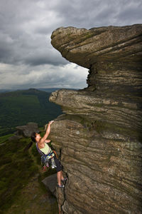 Female rock climber on cliff at the peak district in england
