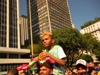 Low angle view of friends against buildings in city