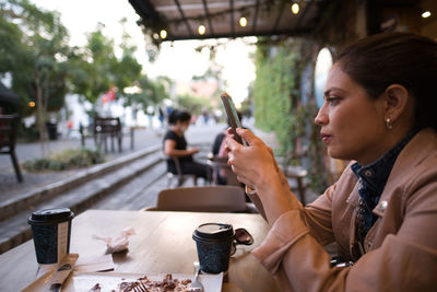 Side view of young woman drinking glass
