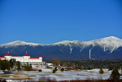 Scenic view of snowcapped mountains against clear blue sky