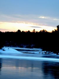 Scenic view of lake against sky at sunset