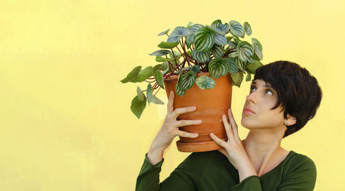 Young woman holding plant