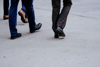 Low section of businessmen walking on street