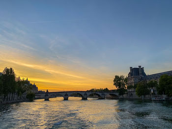 Bridge over river against sky during sunset