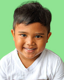 Close-up portrait of boy against blue background