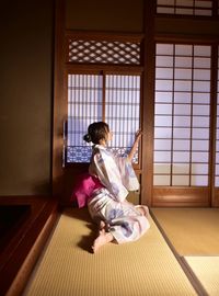 Side view of a girl sitting on floor