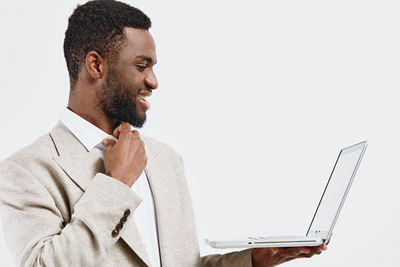 Young man using laptop against white background