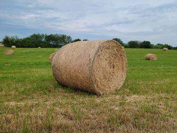 Hay bales on field against sky