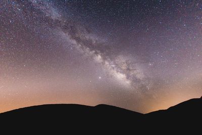 Scenic view of silhouette mountains against sky at night