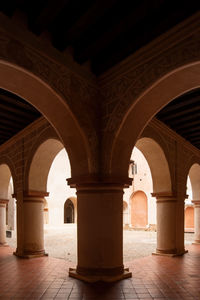 Colonial architecture, arches surrounded by vegetation, play of light and shadows inside the space