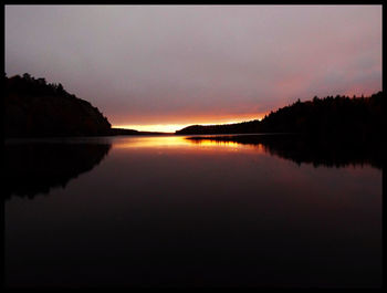 Scenic view of calm lake at sunset