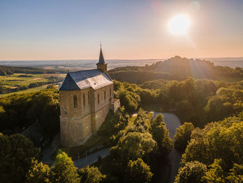 Scenic view of trees and buildings against sky during sunset