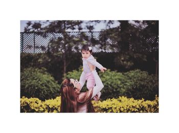 Side view of girl playing with plants