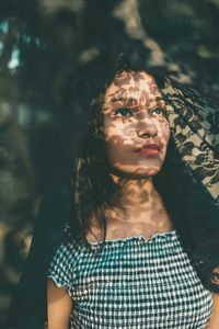 Portrait of beautiful woman standing against blurred background