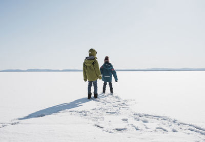 Kids walking across a frozen lake in sweden