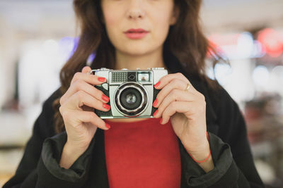 Midsection of woman holding camera