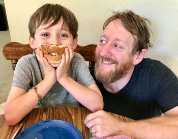 Portrait of father and son sitting at home