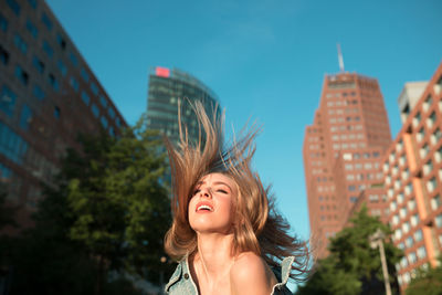 Beautiful woman with tousled hair in city