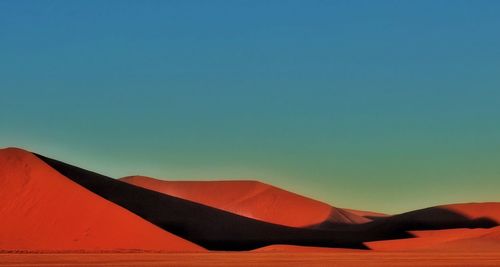 Scenic view of sand dunes against clear blue sky at namib desert