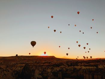 Hot air balloons flying in sky at sunset