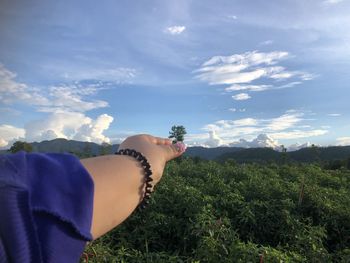 Midsection of person against plants on mountain