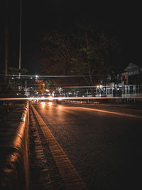 Illuminated railroad tracks in city at night